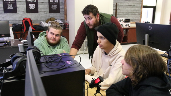 Teacher Josh Kovach works with a group of students on their video project.