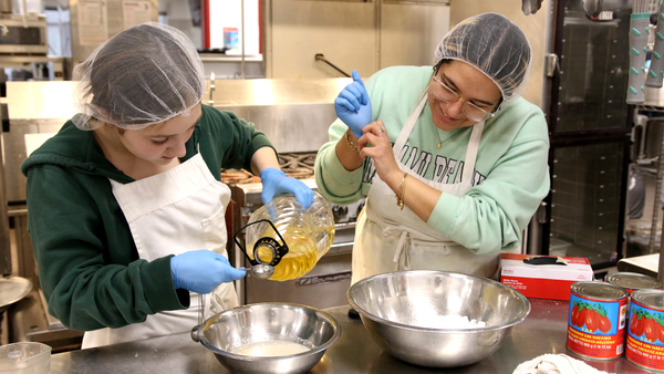 Senior Madilynn Hines prepares food with senior Lyndsy Rodriguez.